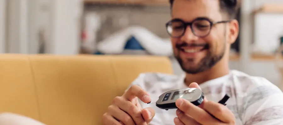 Young man measuring insulin level at home.